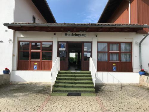 a building with a staircase leading to the front door at Abendruhe Hotel - kontaktloser Check In in Oberhaching