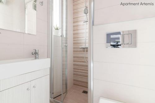 een badkamer met een douche en een wastafel bij Apollo & Artemis by Heloni Apartments in Athene