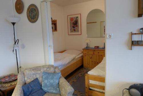 Un dormitorio con una cama, un sofá y un espejo. en Tief 10 Sandburg 104, en Wangerland