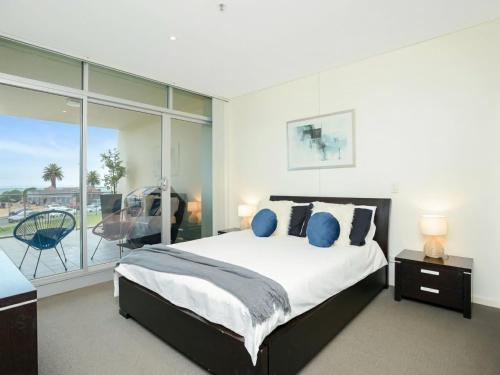 1 dormitorio con 1 cama grande y balcón en Relax in Style Comfort, en Victor Harbor