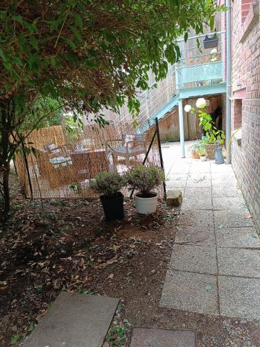 a patio with chairs and plants in a yard at Gîte chez Julie et Franck in Cappy
