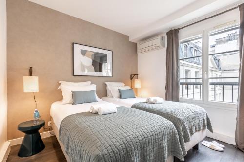 deux lits dans une chambre d'hôtel avec une fenêtre dans l'établissement Sweett - Pavillon Opera, à Paris