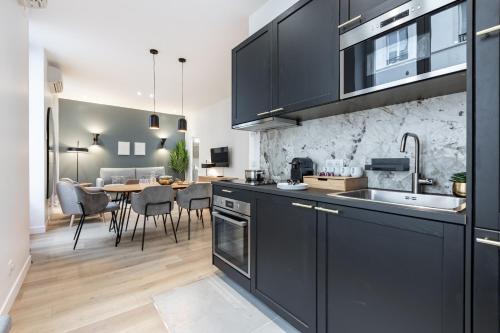 une cuisine avec des armoires noires et une salle à manger dans l'établissement Sweett - Pavillon Opera, à Paris