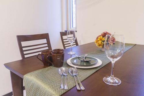 a wooden table with glasses and silverware on it at Audrey Chalet in Niseko