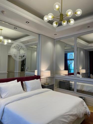 a bedroom with a large white bed and a chandelier at أجنحة فرزاتشي برج داماك الجوهرة in Jeddah