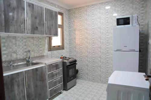 a small kitchen with a sink and a refrigerator at De Iris Regency Fahaheel in Kuwait