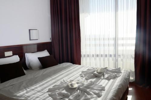 a hotel room with a bed with towels on it at Sunday Beach Hotel in Kusadası