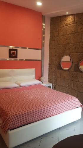 ein Schlafzimmer mit einem Bett mit einer roten Wand in der Unterkunft La Massaria in Avellino