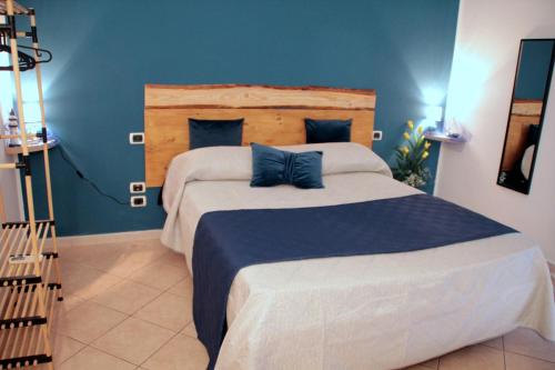 una camera da letto con un grande letto con pareti blu di Suite Petroni a Bari
