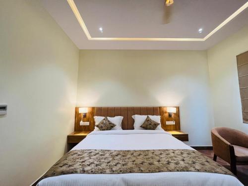 Habitación de hotel con cama y silla en HOTEL EKAS, en Charbagh