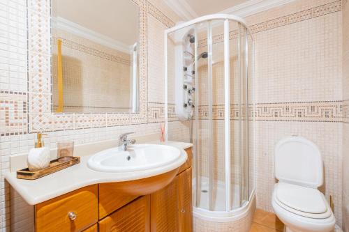 a bathroom with a sink and a shower and a toilet at Villa Arrifes in Albufeira