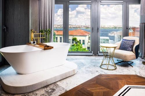 uma banheira na casa de banho com vista para a água em The Maestro Hotel em Istambul