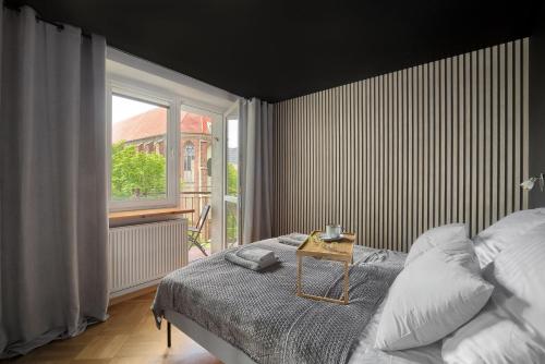 ein Schlafzimmer mit einem Bett und einem großen Fenster in der Unterkunft Family Center Spot in Posen