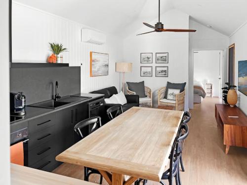 a kitchen and living room with a wooden table at Pod on the Park in Kiama