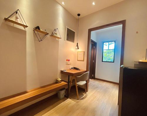 Zimmer mit einem Schreibtisch, einem Tisch und einem Fenster in der Unterkunft oxy suites 2-06 at Shop House Meisterstadt Pollux Habibie in Batam Center