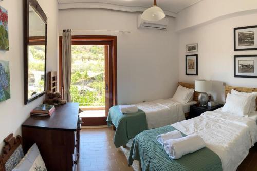 a bedroom with two beds and a window at Bellavista at Heraion Lagoon in Loutraki