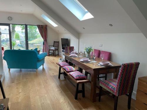 a living room with a wooden table and chairs at The Hen House A beautifully situated open plan chalet in Lothersdale