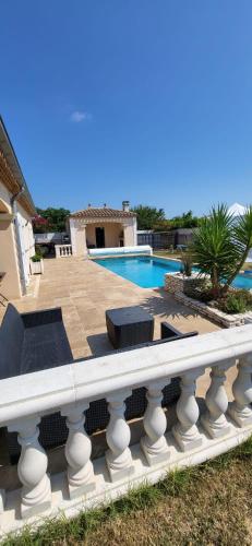 a view of a swimming pool with a white railing at La Bastide du Canal avec piscine et clim in Carcassonne