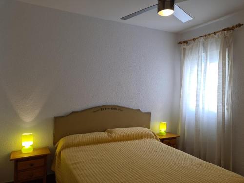 a bedroom with a bed and two candles on tables at REf 112 ATICO EN ZAHARA MAR in Zahara de los Atunes