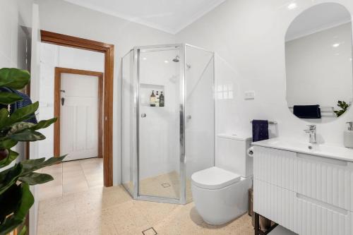 a white bathroom with a shower and a toilet at Minnamurra Retreat 3 in Minnamurra
