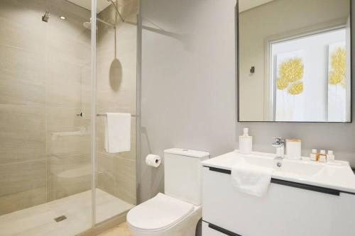 La salle de bains est pourvue de toilettes, d'un lavabo et d'une douche. dans l'établissement Views of V&A Mall, Robben Island & Ocean Sunsets, au Cap