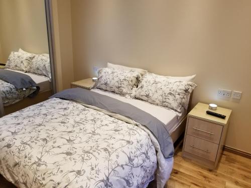 a small bedroom with a bed and a mirror at London Luxury Apartment 4 Bedroom Sleeps 12 people with 4 Bathrooms 1 Min walk from Station in Wanstead