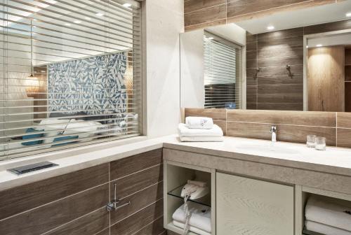 a bathroom with a sink and a mirror at Atlantica Aegean Blue in Kolimbia