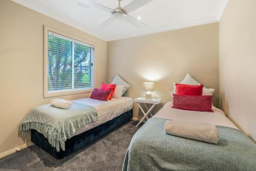 Un dormitorio con dos camas y una ventana. en EastsHaven, en Kiama