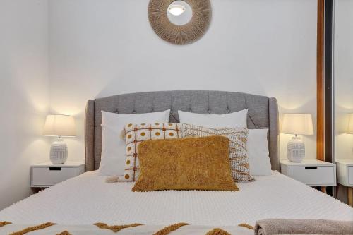 a bedroom with a white bed with two lamps at Minnamurra Retreat 2 in Minnamurra
