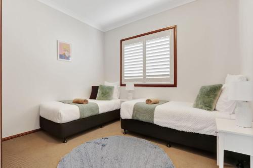 a bedroom with two beds and a window at Minnamurra Retreat 2 in Minnamurra