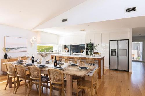 a kitchen and dining room with a large wooden table and chairs at The White Haven of Gerringong in Gerringong