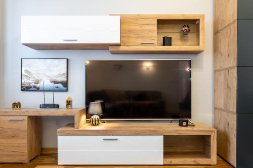 un soggiorno con una grande TV a schermo piatto di Golden Apartments - Big Luxury Apartment in Top Location - Wspólna a Varsavia