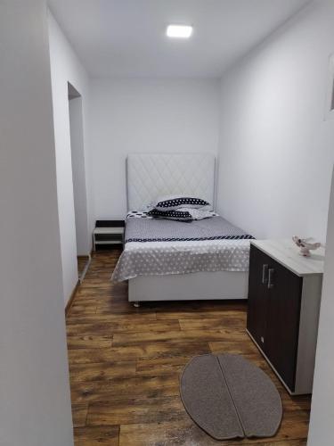 sypialnia z łóżkiem i drewnianą podłogą w obiekcie Casa Haidu w mieście 2 Mai