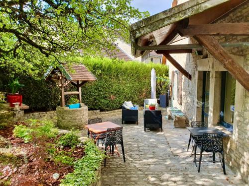 un patio con mesa, sillas y sombrilla en Le Terrier en Miserey-Salines