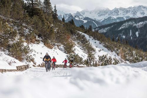 a group of people skiing down a snow covered mountain at MyTime Hotels la Grotta in Vigo di Fassa
