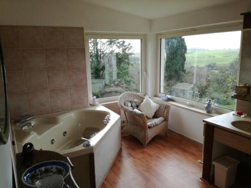 a bathroom with a tub and a chair and windows at Poderi di Tragliatella in Tragliatella