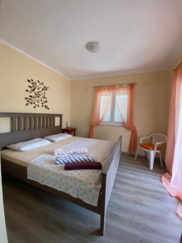 a bedroom with a large bed and two windows at Jurič in Rogoznica
