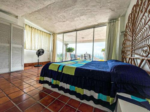 um quarto com uma cama e uma grande janela em Vista espectacular, privada y desayuno incluido! em Acapulco