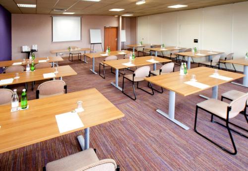 an empty classroom with wooden tables and chairs at Logis Lyon Est Porte de l'Ain in Saint-Maurice-de-Beynost