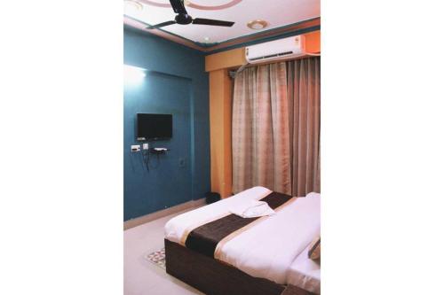 Habitación de hotel con cama y TV en The Hotel Raj Palace, en Bharatpur