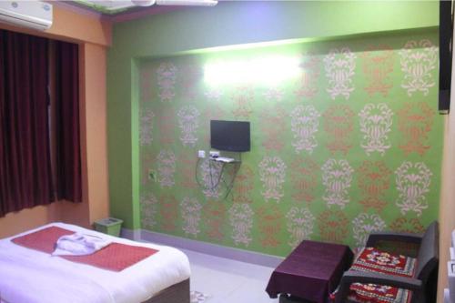 ein Schlafzimmer mit einem Bett und einer grünen Wand in der Unterkunft The Hotel Raj Palace in Bharatpur