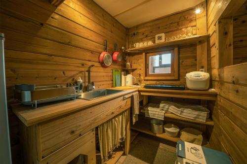 eine Küche mit einem Waschbecken in einer Holzhütte in der Unterkunft Alpages madarao in Madarao Kogen