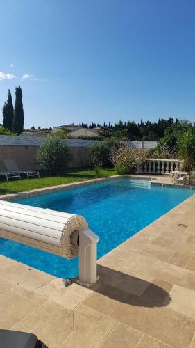 a swimming pool with a white bench next to it at La Bastide du Canal avec piscine et clim in Carcassonne