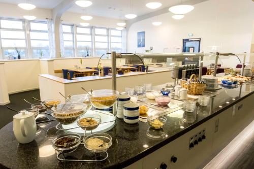 a kitchen with a counter with many bowls of food at Jugendherberge Lauenburg Zündholzfabrik in Lauenburg