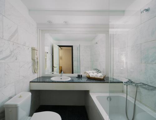 y baño con lavabo, bañera y aseo. en El Greco Hotel, en Agios Nikolaos