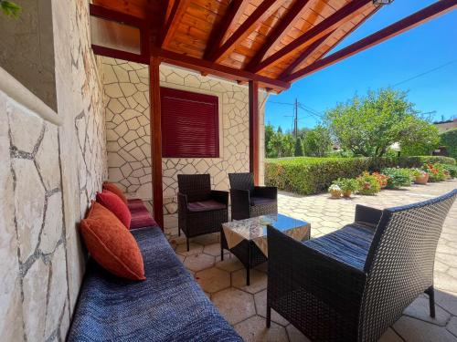 a patio with chairs and a table and a roof at Pettas Apartments in Zakynthos Town