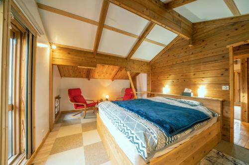 ein Schlafzimmer mit Holzwänden und ein Bett in einem Zimmer in der Unterkunft Alpages madarao in Madarao Kogen