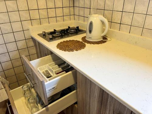 a kitchen counter with a stove and some food at Pettas Apartments in Zakynthos Town