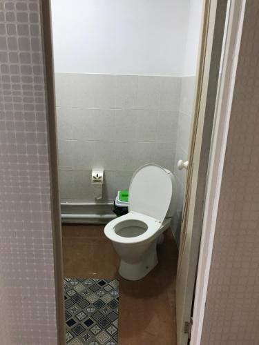 a bathroom with a white toilet in a stall at Гостевой дом in Shchūchīnsk