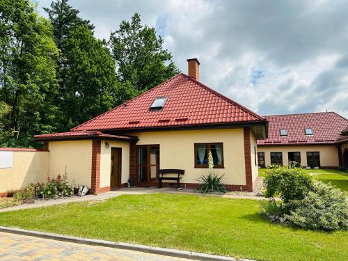 a small house with a red roof at Niebieska Chmurka in Miłomłyn